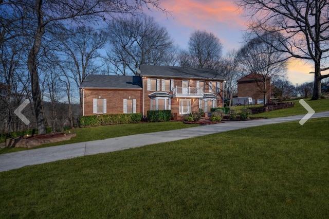 view of front of property with a balcony and a yard