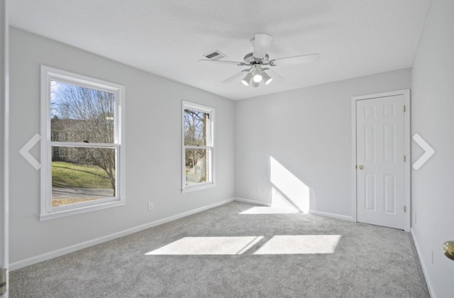 unfurnished room with a healthy amount of sunlight, ceiling fan, and light carpet