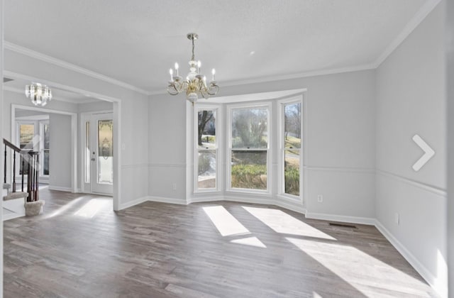 unfurnished dining area with crown molding, hardwood / wood-style flooring, and a notable chandelier