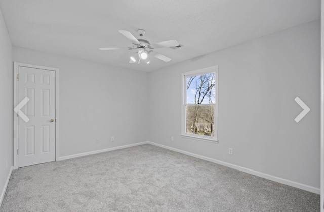 empty room featuring ceiling fan and light carpet