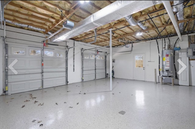 garage featuring electric panel, a garage door opener, and gas water heater