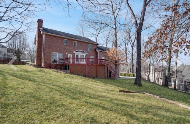 rear view of house featuring a yard and a deck