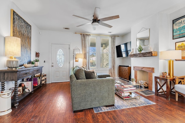 living room with ceiling fan and dark wood-type flooring