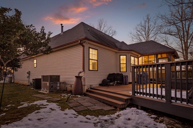 snow covered back of property featuring cooling unit and a deck