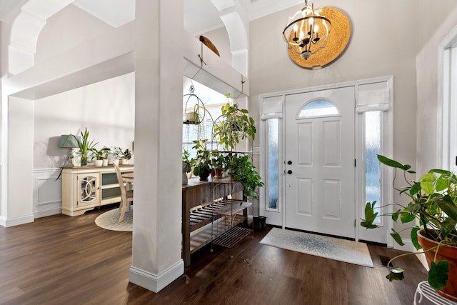 entrance foyer featuring a high ceiling, an inviting chandelier, and dark wood-type flooring