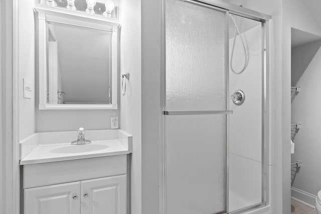 bathroom featuring a shower with door, vanity, and tile patterned floors