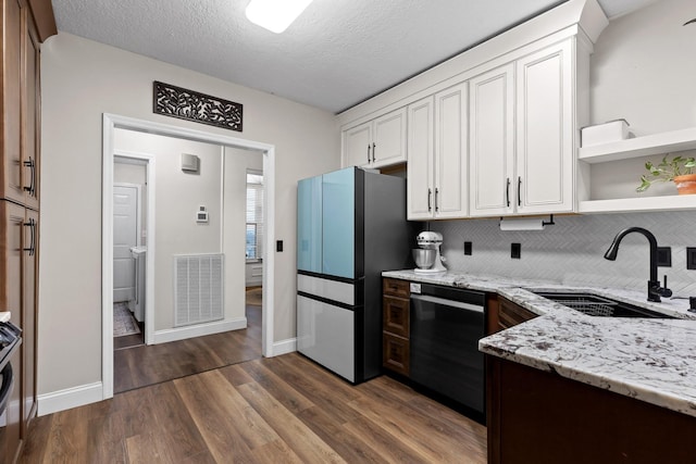 kitchen featuring sink, white cabinets, light stone counters, and black dishwasher