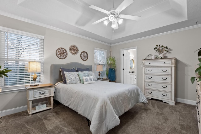 bedroom with ensuite bath, a raised ceiling, dark colored carpet, and ceiling fan