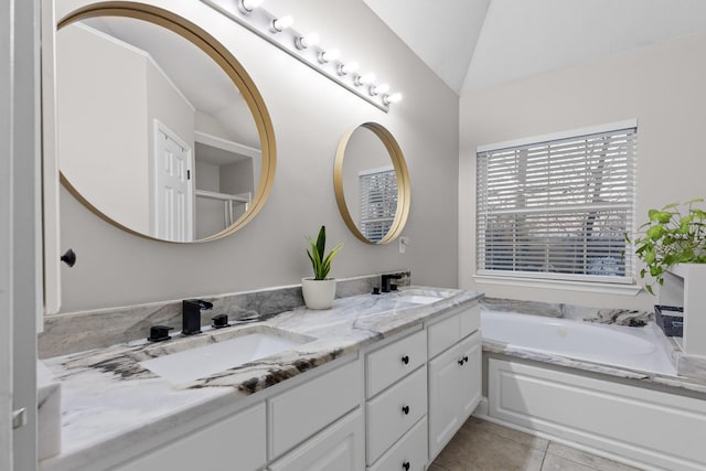 bathroom with lofted ceiling, tile patterned flooring, a washtub, and vanity