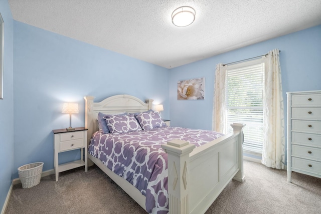 bedroom with a textured ceiling and light colored carpet