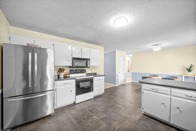 kitchen with stainless steel refrigerator, white cabinets, a textured ceiling, and electric stove