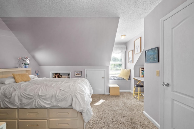 bedroom with a textured ceiling, vaulted ceiling, and light carpet