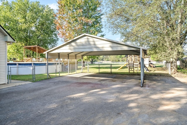 view of car parking featuring a playground and a carport