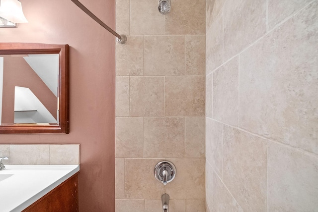 bathroom with tiled shower / bath combo and vanity