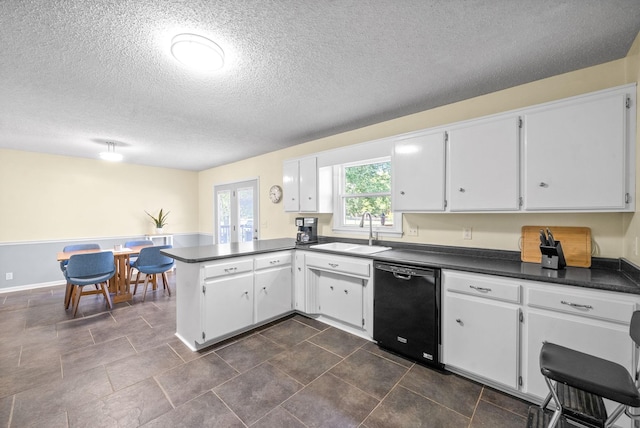 kitchen with sink, black dishwasher, white cabinets, and kitchen peninsula