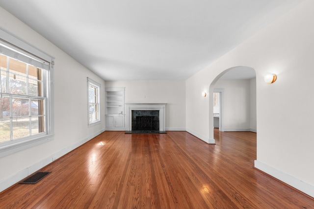 unfurnished living room featuring hardwood / wood-style flooring and a high end fireplace