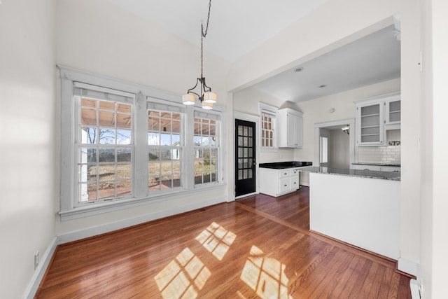 kitchen featuring pendant lighting, an inviting chandelier, dark hardwood / wood-style floors, white cabinets, and decorative backsplash