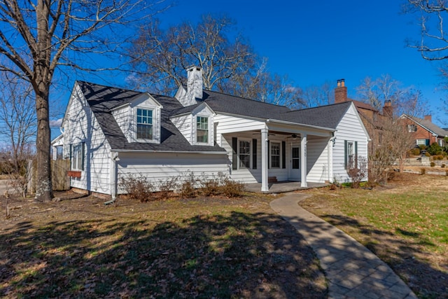 cape cod house with ceiling fan, covered porch, and a front lawn