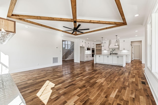 unfurnished living room featuring ceiling fan, dark wood-type flooring, and crown molding