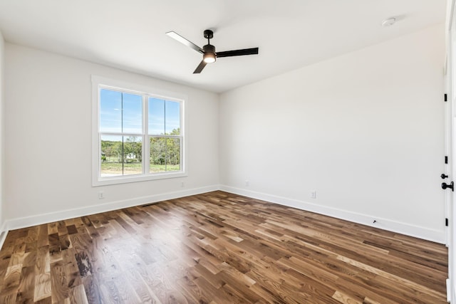 empty room with ceiling fan and dark wood-type flooring