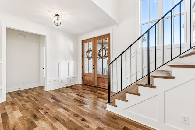 entrance foyer with french doors, an inviting chandelier, hardwood / wood-style floors, and plenty of natural light