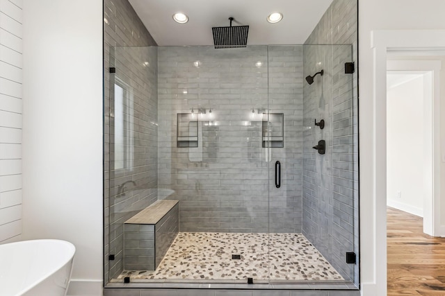 bathroom featuring hardwood / wood-style flooring and independent shower and bath