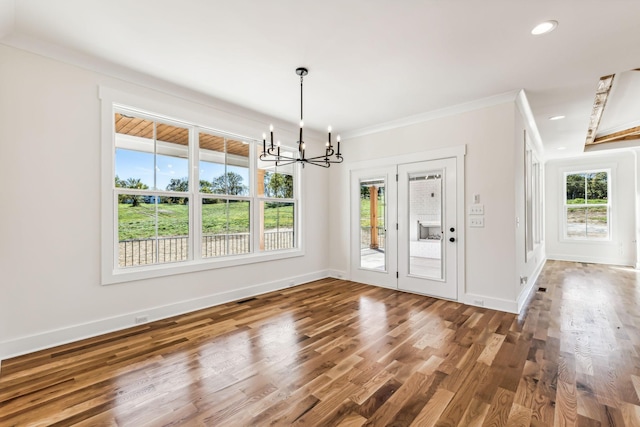 unfurnished dining area featuring a chandelier, ornamental molding, and dark hardwood / wood-style floors