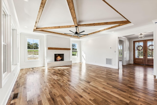 unfurnished living room with ceiling fan, dark hardwood / wood-style flooring, french doors, and a brick fireplace