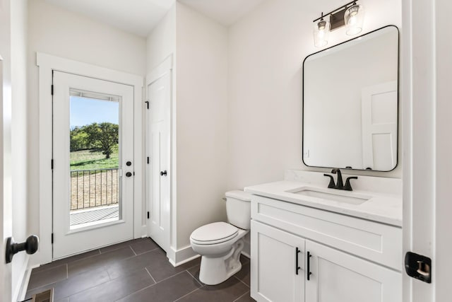 bathroom featuring toilet, vanity, tile patterned flooring, and plenty of natural light