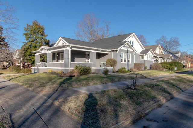 view of side of property featuring a lawn and covered porch