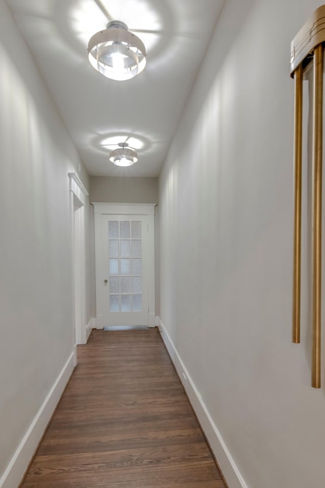 corridor with dark hardwood / wood-style flooring