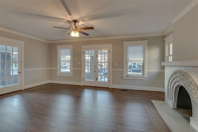 unfurnished living room with wood-type flooring, crown molding, ceiling fan, french doors, and a fireplace