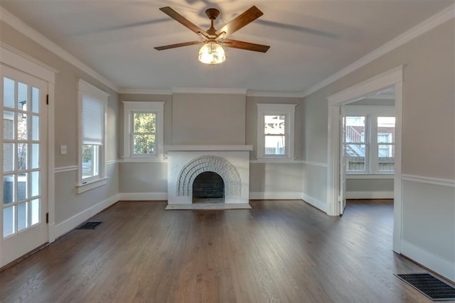 unfurnished living room with ceiling fan, dark hardwood / wood-style flooring, crown molding, and a fireplace