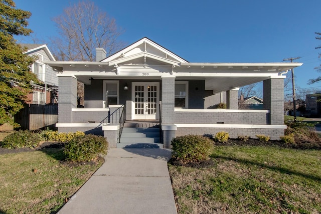 view of front of property featuring a front yard and covered porch