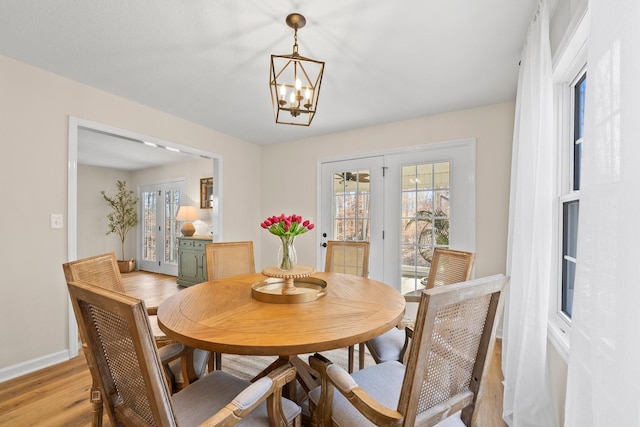 dining area featuring an inviting chandelier and light hardwood / wood-style floors