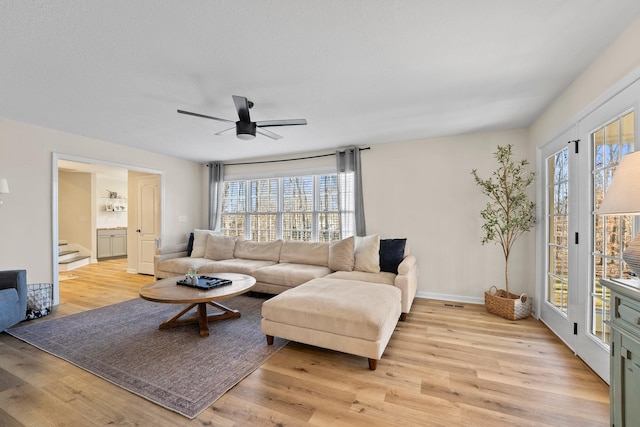 living room featuring ceiling fan and light wood-type flooring