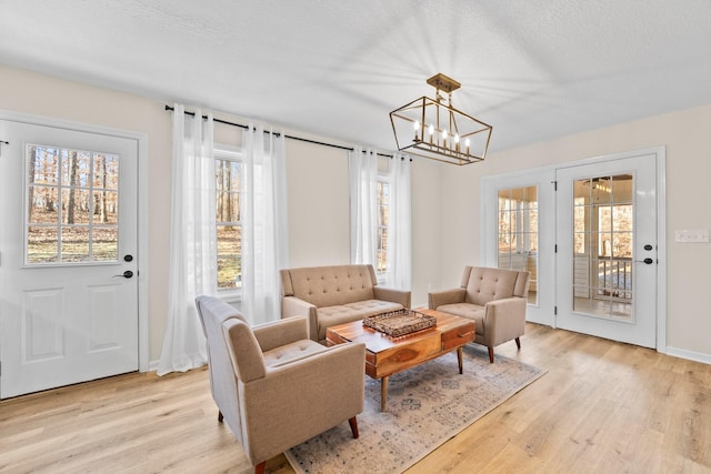 sitting room featuring an inviting chandelier, a textured ceiling, and light hardwood / wood-style flooring