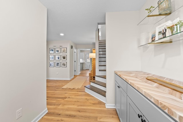 bar featuring light hardwood / wood-style floors and gray cabinetry