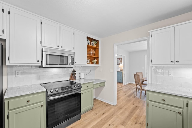 kitchen featuring stainless steel appliances, green cabinetry, light stone counters, white cabinets, and backsplash