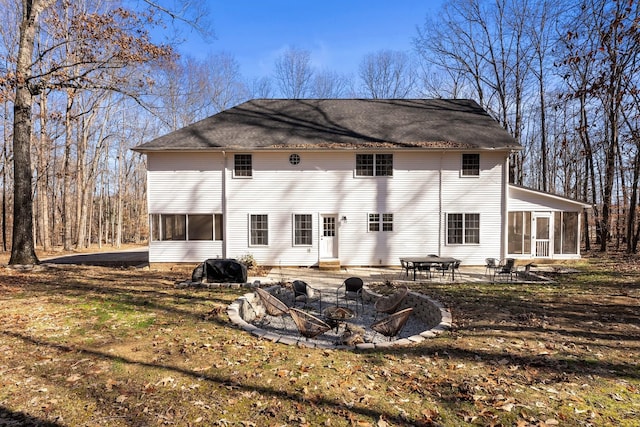 rear view of property with a fire pit, a sunroom, and a patio area