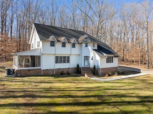 view of front of house featuring central AC, a sunroom, and a front lawn