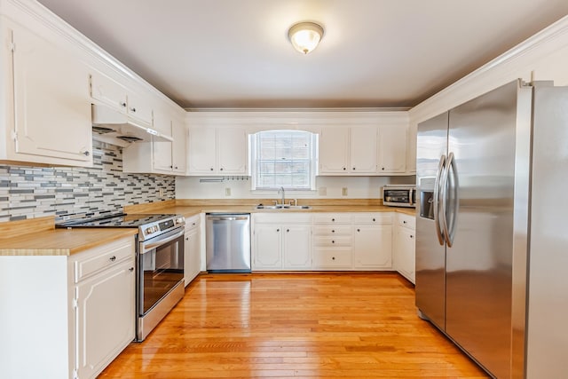 kitchen featuring sink, white cabinetry, light hardwood / wood-style floors, decorative backsplash, and appliances with stainless steel finishes