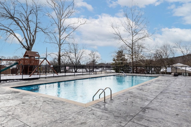 view of swimming pool with a playground and a patio