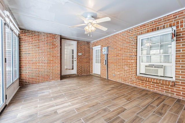 unfurnished sunroom featuring ceiling fan and cooling unit