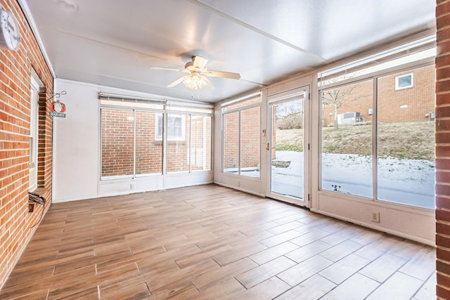 unfurnished sunroom with ceiling fan and plenty of natural light