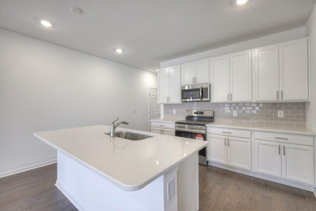 kitchen featuring stainless steel appliances, an island with sink, decorative backsplash, white cabinets, and sink