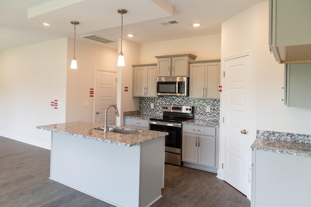 kitchen with visible vents, appliances with stainless steel finishes, a sink, gray cabinetry, and backsplash