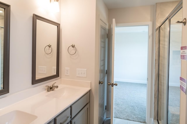 bathroom with double vanity, a sink, and a shower with shower door