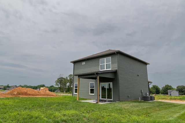 rear view of property with a patio, central AC unit, and a lawn