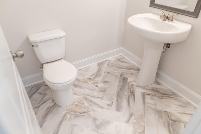 bathroom featuring toilet and baseboards